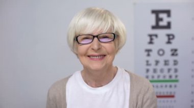 Gözlük kapanış göz ve gülümseyen Kıdemli kadın, uygun lens diyoptri, checkup