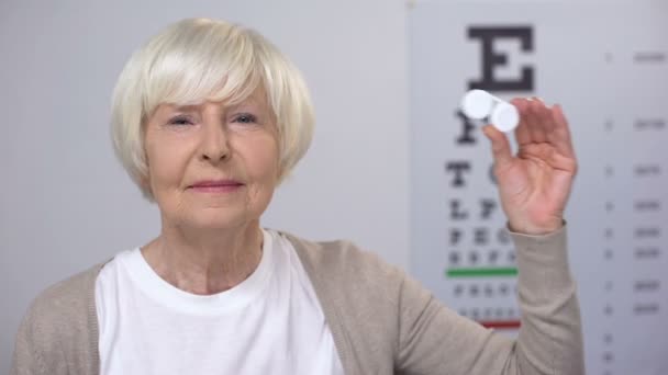 Femme âgée montrant le cas avec des lentilles de contact, préférant les nouvelles technologies — Video