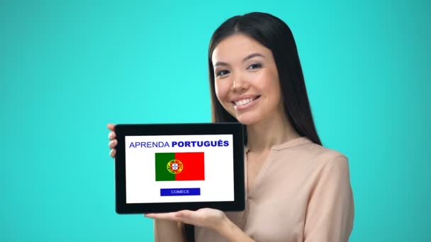 Женщина держит планшет с изучением португальского приложения, готова начать курс — стоковое видео