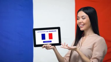 Lady Fransızca uygulaması öğrenmek ile tablet tutan, arka planda Fransa bayrağı, eğitim