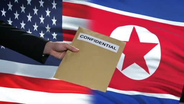 USA och Nord Korea tjänstemän utbyta konfidentiella kuvert, flaggor bakgrund — Stockvideo