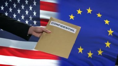 ABD ve Avrupa Birliği yetkilileri bayraklar karşısında gizli zarf alışverişinde bulunuyor
