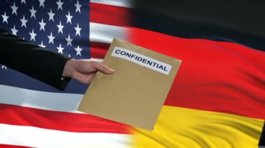 ABD ve Almanya yetkilileri gizli zarf alışverişinde, bayraklar arka plan