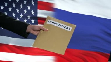 ABD ve Rusya yetkilileri gizli zarf alışverişinde, bayraklar arka plan