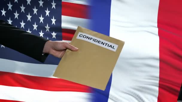 USA and France officials exchanging confidential envelope, flags background — Stock Video