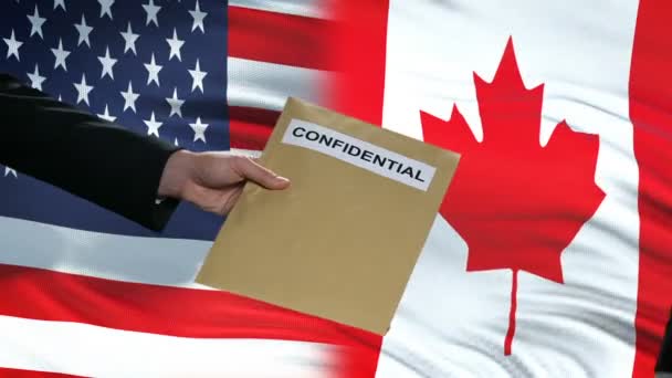 USA and Canada officials exchanging confidential envelope, flags background — Stock Video