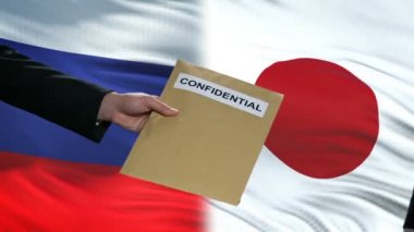 Rusya ve Japonya yetkilileri gizli zarf alışverişi, bayrakları arka plan