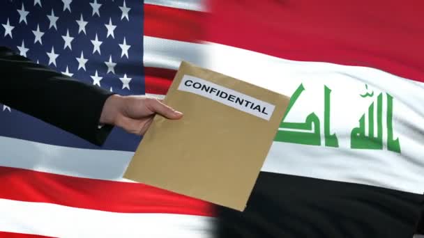 USA and Iraq officials exchanging confidential envelope, flags background — Stock Video