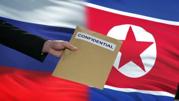 Urzędnicy Rosji i Korei Północnej wymieniając poufne koperty, przed flagami — Wideo stockowe