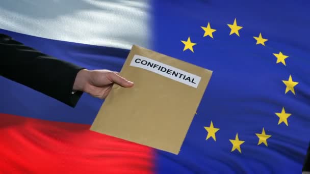Russia and European Union officials exchanging confidential envelope, flags — Stock Video