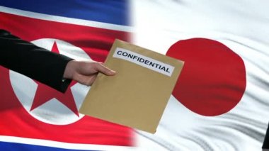 Kuzey Kore ve Japonya yetkilileri bayraklar karşı, gizli zarf alışverişi