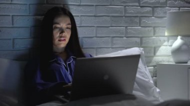 Evde geç dizüstü bilgisayarda proje yapan kadın, aşırı çalışmadan baş ağrısı çekiyor