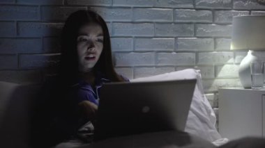 Asyalı kadın gece dizüstü bilgisayar üzerinde çalışan, ph dengesini korumak için içme suyu