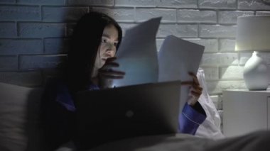 Asyalı kadın gece yatak odasında rapor yapıyor, iş, iş tükenmişlik ile rahatsız