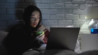 Grip ateşi geçiren hasta kadın, film izlerken çay içmek, evde tedavi