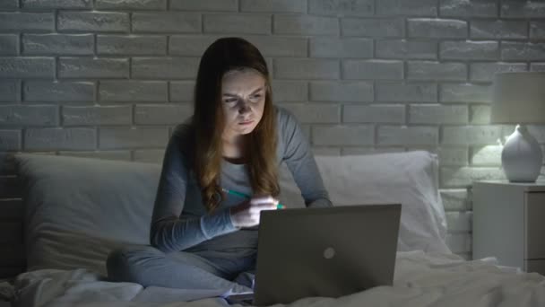 Estudiante chica haciendo proyecto en el ordenador portátil en la noche plazo de reunión, preparación del examen — Vídeo de stock