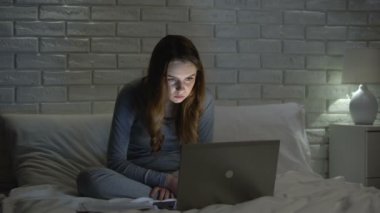 Soluk kız gece geç saatlerde internet kullanarak, yorgun görünümlü, ağları bağımlısı