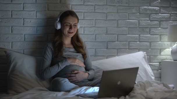 Плачущая беременная женщина смотрит кино по ночам, чувствует себя одинокой и подавленной — стоковое видео