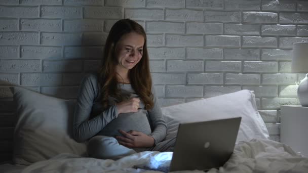 Беременная женщина плачет, смотрит кино, страдает депрессией, гормональные изменения — стоковое видео