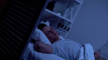 Erkek genç rahat yatak odasında uyku, akşam uzun bir günün ardından dinlenmek