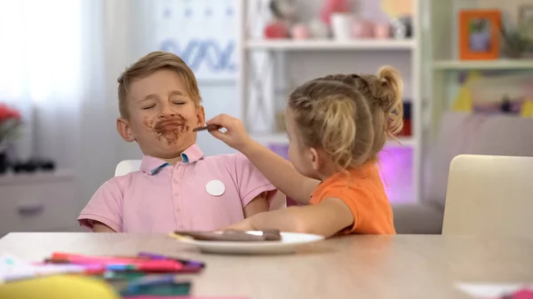 Girl Feeding Smeared Boy Chocolate Sweets Overeating Stomach Problems — Stock Photo, Image