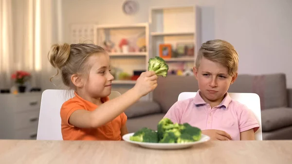 Girl Giving Brother Broccoli Playing Food Unappetizing Healthy Food — Stock Photo, Image
