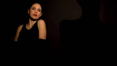 Siyah arka plan, şehvetli dans karşı kamera için poz Pretty kadın, makyaj