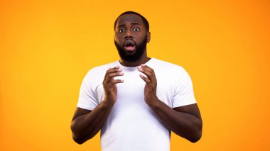 Parlak arka plan üzerinde Korkmuş afro-amerikan adam, şok edici haber, korku umutsuzluk