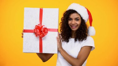 Büyük hediye kutusu tutan santa şapka sevindim afro-amerikan kadın, mutluluk