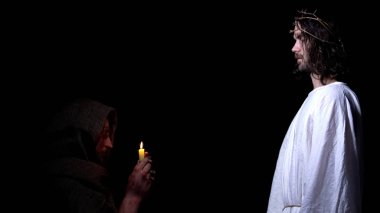 Mum tutan ve Tanrı inancı dikenli bir taç İsa dua zavallı adam