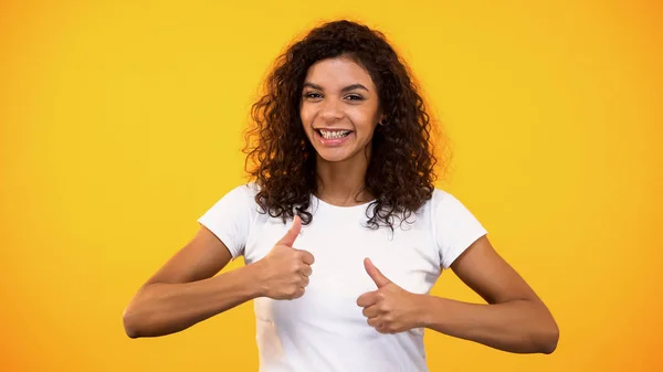 Vrolijke Vrouw Toont Duimen Omhoog Glimlachend Tegen Gele Achtergrond Zoals — Stockfoto