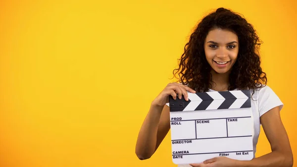 Souriant Jeune Femme Tenant Claquette Conseil Sur Fond Orange Cinématographie — Photo