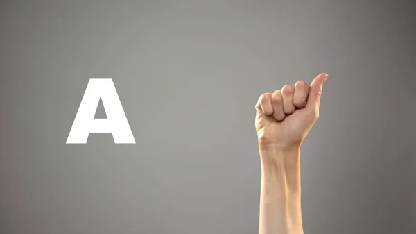 Letter A in sign language, hand on background, communication for deaf, lesson