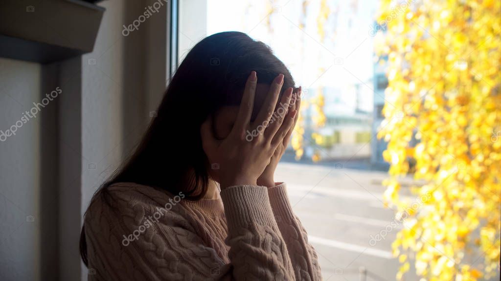 Desperate lady crying and closing face with hands, loss of loved one, loneliness