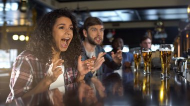 Güzel biracial bayan favori takım kazanan oyunu kutluyor, pub rahatlatıcı