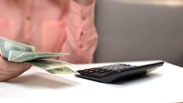 Γυναίκα Δολάρια Στο Χέρι Καταμέτρηση Φόροι Αριθμομηχανή Στο Τραπέζι Οικονομική — Φωτογραφία Αρχείου