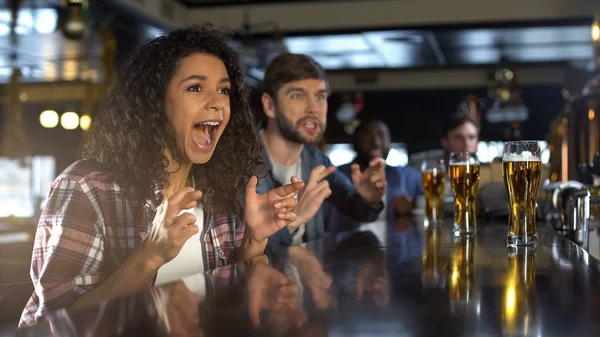 Beautiful biracial lady celebrating favorite team winning game, relaxing in pub