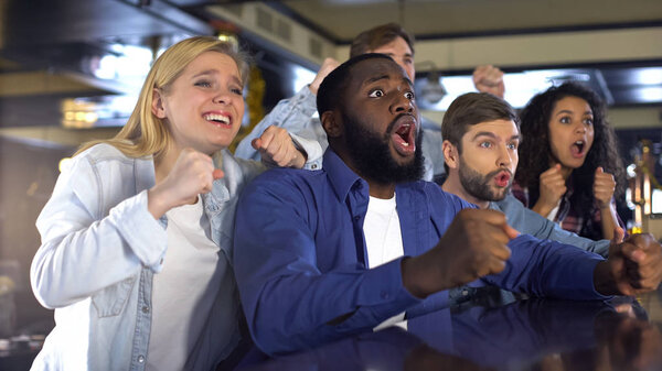 Emotional multiethnic friends watching sports, rejoicing winning game, leisure