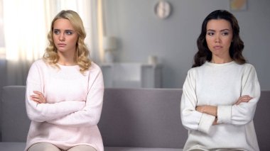 Kanepe, farklı taraflarında oturan iki genç rahatsız kız kardeş aile kavga