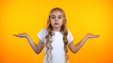 Belirsiz preteen kız sarı arka plan izole dehşet içinde el kaldırma