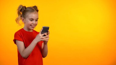 Mutlu preteen kız kaydırma akıllı telefon ve gülümseyen, eğitim uygulaması, gadget