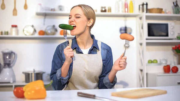 Pretty Girl Choosing Cucumber Instead Sausage Low Calorie Food Carbohydrates — Stock Photo, Image