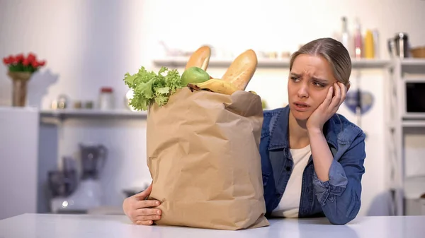 精疲力竭的女人看着沉重的纸袋与食物 与交付的问题 — 图库照片