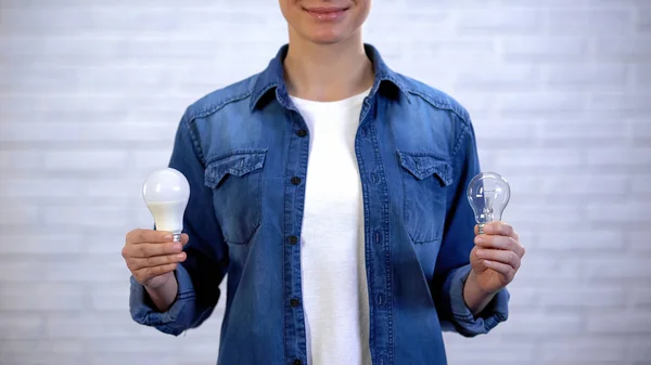 Жінка Вибирає Між Енергозберігаючою Лампою Лампою Розжарювання Ефективність — стокове фото