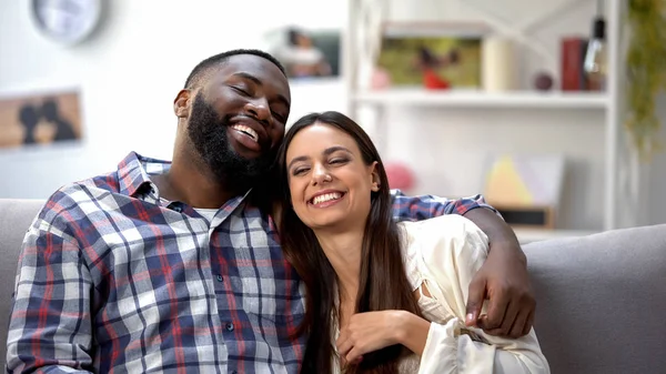 Bonita Pareja Multiétnica Sonriendo Sentada Sofá Casa Divirtiéndose Juntos — Foto de Stock