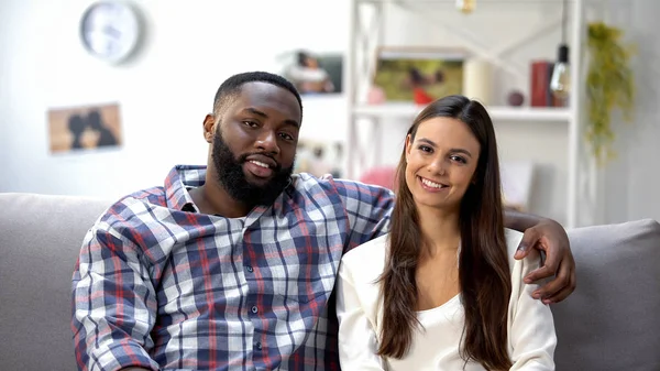 Sonriente Pareja Raza Mixta Sentada Sofá Casa Mirando Cámara Familia — Foto de Stock