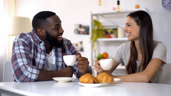 ミックスレースのカップルは 朝のコーヒー 自宅での朝食中に話をし 笑います — ストック写真