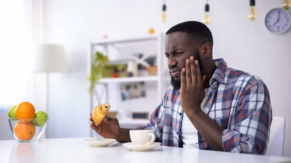 Черный Мужчина Чувствует Зубную Боль Сладкой Еды Ест Круассан Кофе — стоковое фото