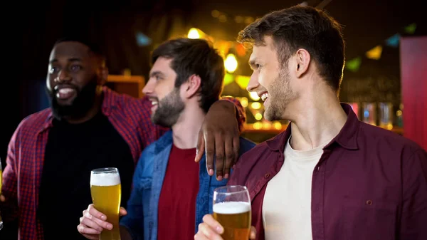 Amigos Caucásicos Mirando Amigo Afroamericano Bebiendo Cerveza Bar —  Fotos de Stock