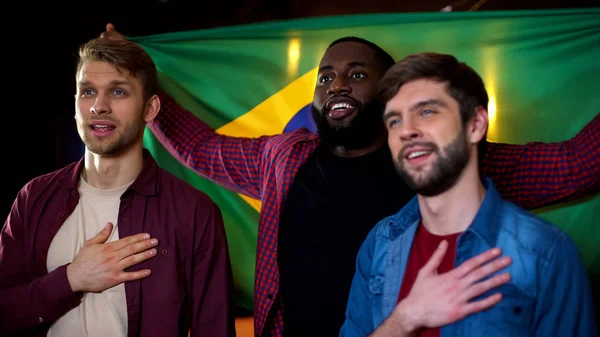 Brasileiros Fãs Futebol Multirracial Cantando Hino Nacional Segurando Bandeira Pub — Fotografia de Stock